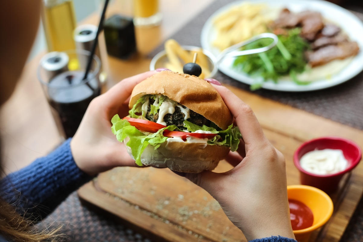 woman eating burger after wisdom teeth removal